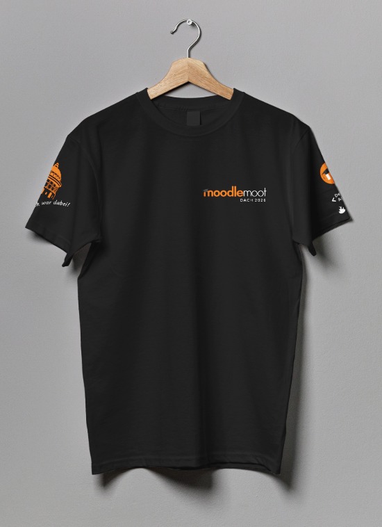 Black MoodleMootDACH26 T‑shirt on a grey background, with logo on the left chest, Moodle and event badges on the left sleeve, and a Zurich landmark with the slogan “Ich bin dabei” on the right sleeve.